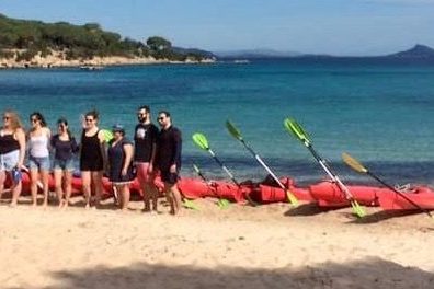 a group of people standing on top of a sandy beach