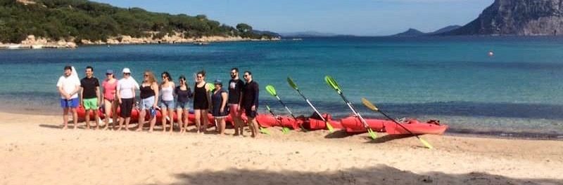 a group of people standing on top of a sandy beach