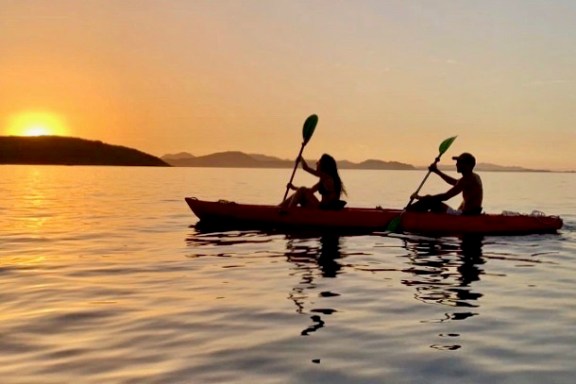 a group of people sitting in a boat on a body of water