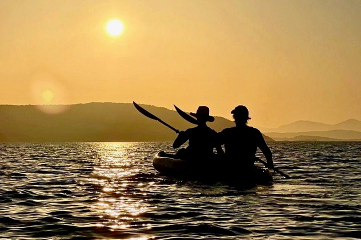 a man standing next to a body of water next to the ocean