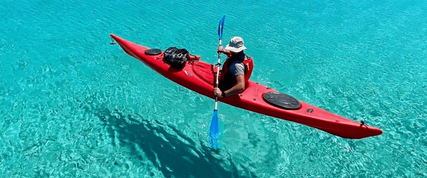 a man riding on the back of a boat in the water
