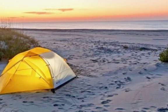 a sunset over a body of water with an orange umbrella